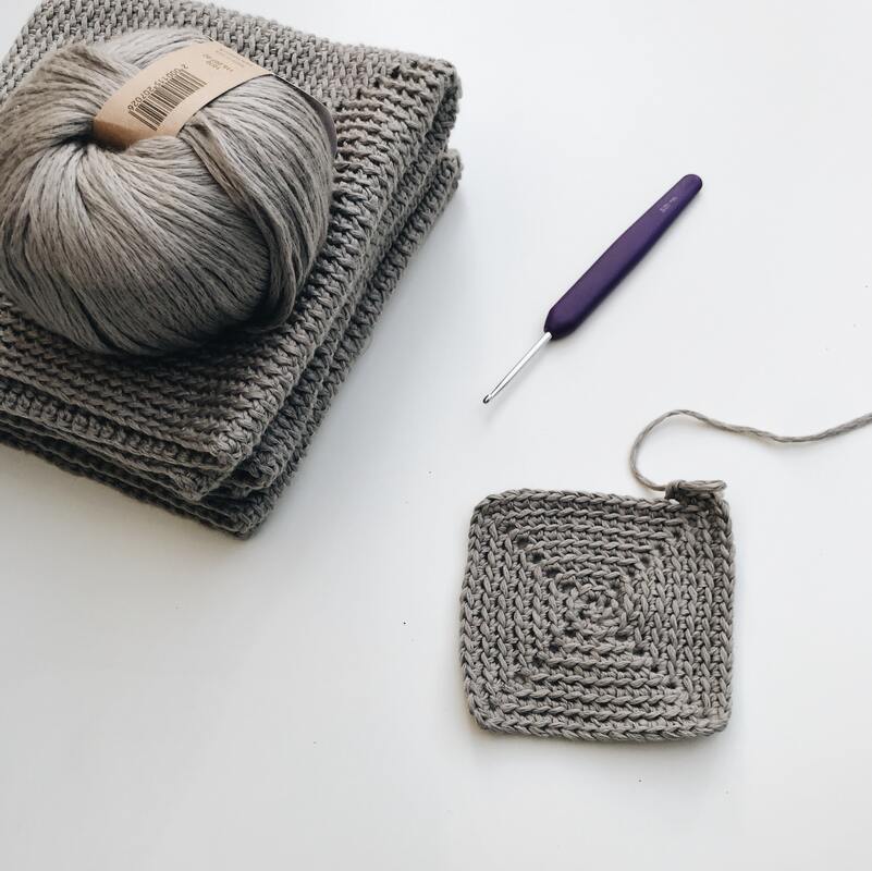 Grey crochet square and needle